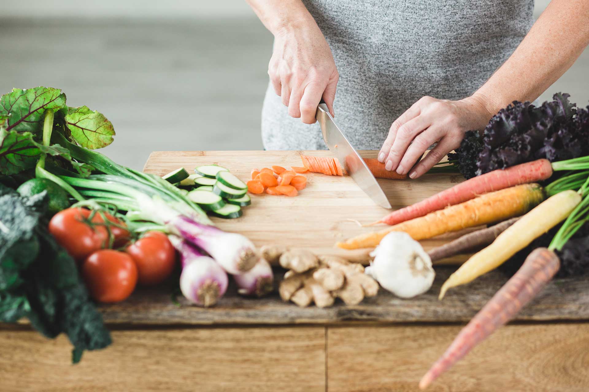 Woman Chopping Healthy Vegetables on a Cutting Board